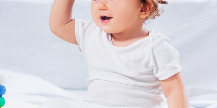 Happy baby boy sitting with toy