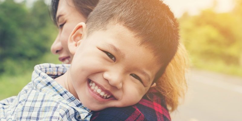Little cute asian boy hug with her mom and smiling to camera hap